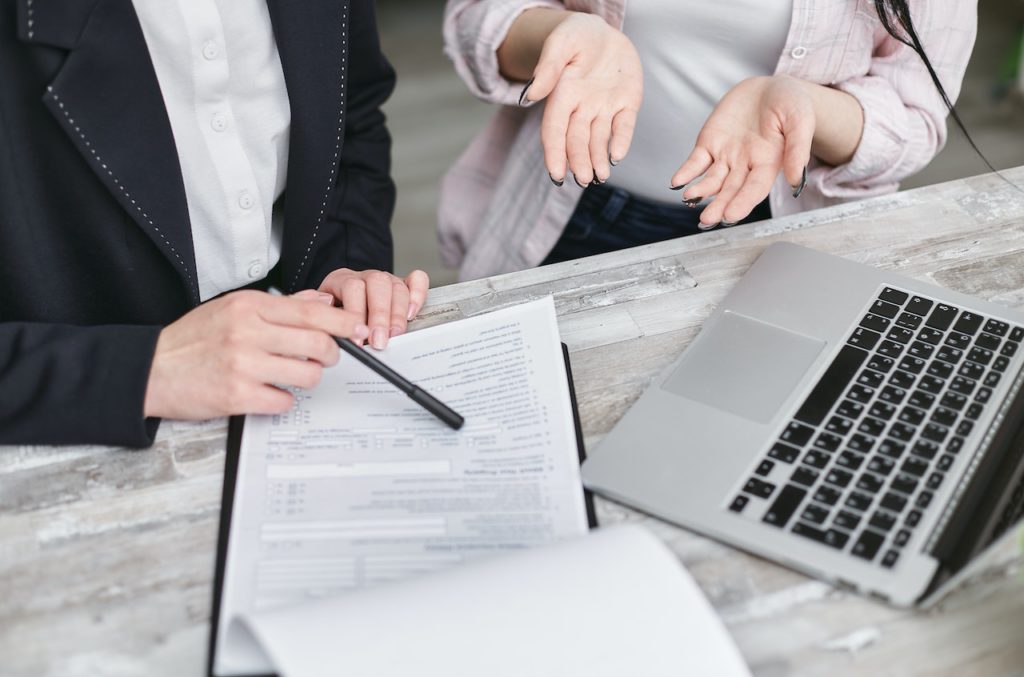 Dos personas leyendo un contrato de compraventa que contiene un pacto de retroventa